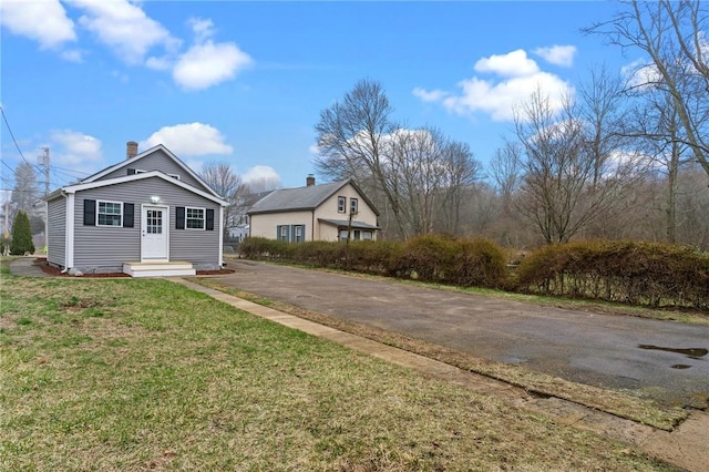 5 Cottage St, Westerly, RI 02891 - view of front facade featuring entry steps, a front lawn, driveway, and a chimney