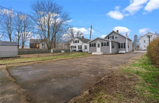 5 Cottage St, Westerly, RI 02891 - view of front of home featuring entry steps, a chimney, fence, and aphalt driveway