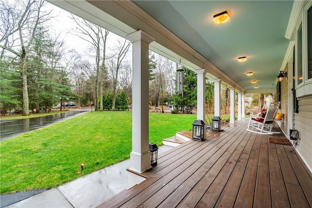 wooden terrace featuring a yard and a porch