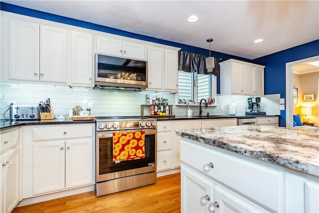 kitchen with light wood-style flooring, a sink, white cabinetry, and stainless steel appliances