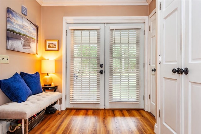 doorway to outside with crown molding and wood finished floors