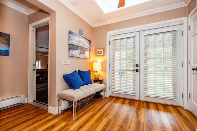 doorway to outside with baseboards, a baseboard heating unit, ornamental molding, a skylight, and wood finished floors