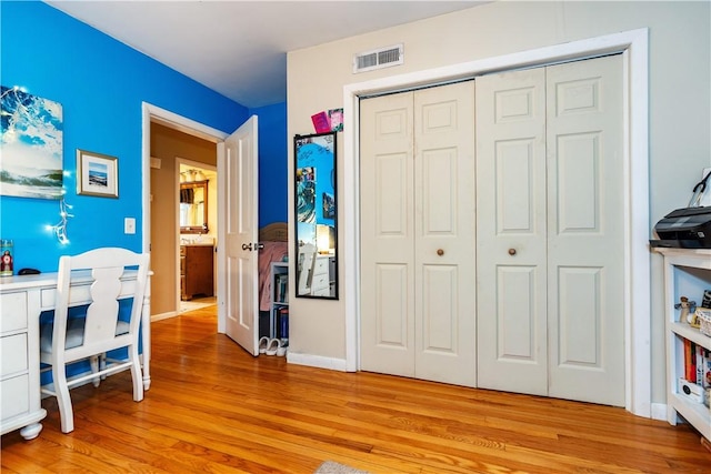 bedroom featuring visible vents, light wood-style flooring, a closet, and baseboards
