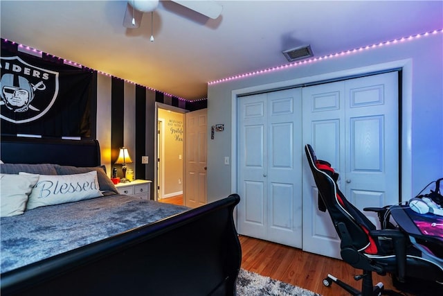 bedroom featuring visible vents, ceiling fan, a closet, and wood finished floors