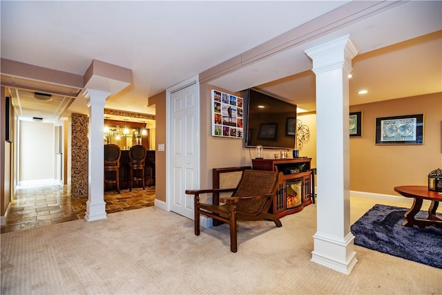 interior space with baseboards, ornate columns, and carpet flooring