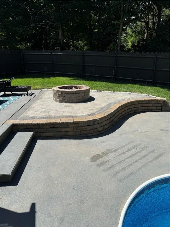 view of swimming pool featuring a fenced backyard, a fenced in pool, an outdoor fire pit, and a patio