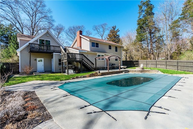 rear view of property with a chimney, stairway, a fenced backyard, a wooden deck, and a lawn