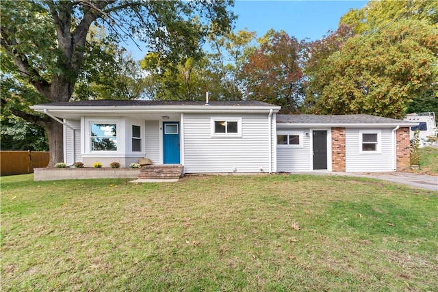 ranch-style home with fence and a front lawn