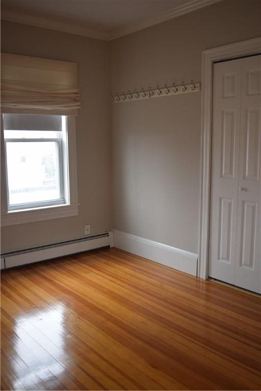 186 Camp St Unit 5, Providence, RI 02906 - empty room featuring baseboard heating, light wood-type flooring, and crown molding