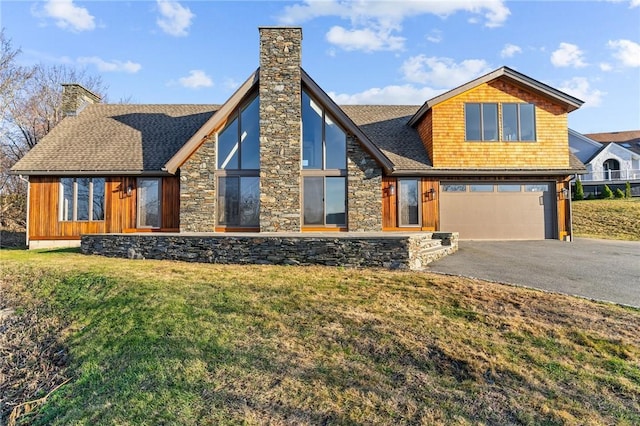 view of front of home featuring driveway, a front lawn, a garage, and a chimney