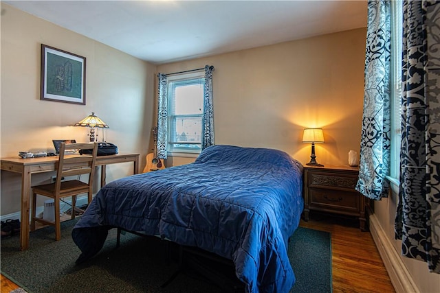 bedroom featuring baseboards and wood finished floors