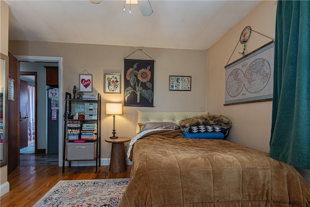 bedroom with wood finished floors, baseboards, and a ceiling fan