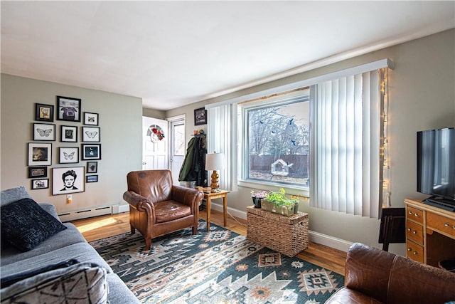living room with a baseboard radiator, wood finished floors, and baseboards