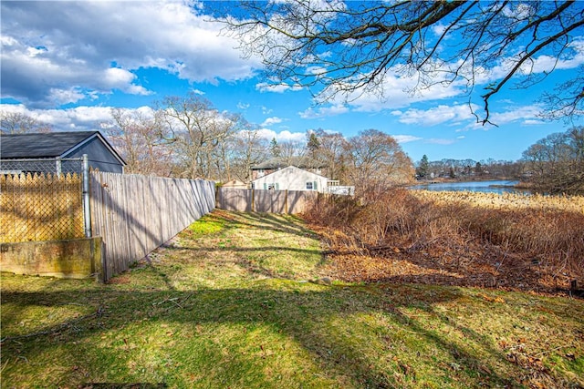 view of yard featuring fence and a water view
