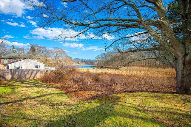 view of yard with a water view and fence