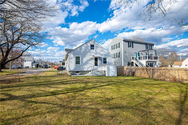 back of property with fence and a lawn