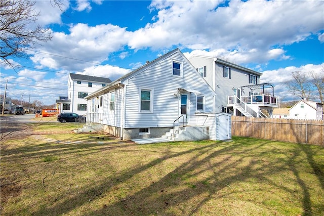 back of house with fence and a lawn