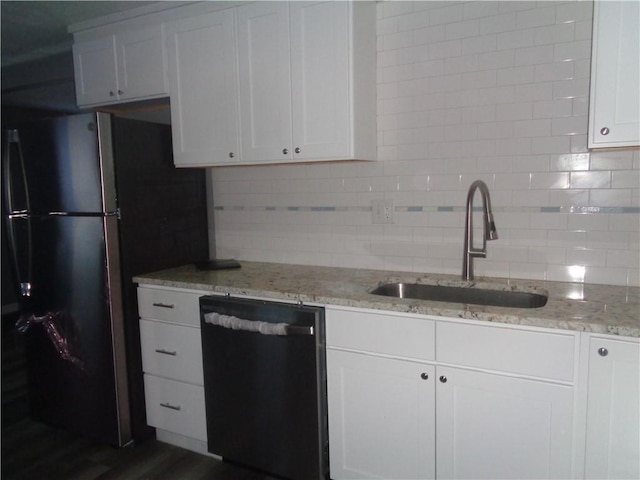 kitchen with freestanding refrigerator, decorative backsplash, a sink, dishwasher, and white cabinets