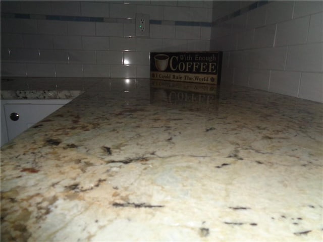 details with white cabinetry and light stone countertops