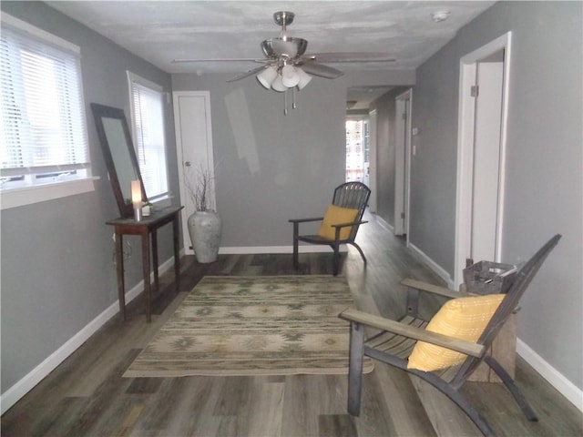 sitting room featuring baseboards, wood finished floors, and ceiling fan