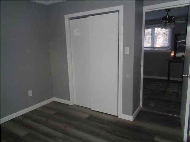 spare room with dark wood finished floors, baseboards, and a ceiling fan
