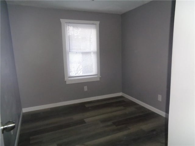 empty room with dark wood-style floors and baseboards