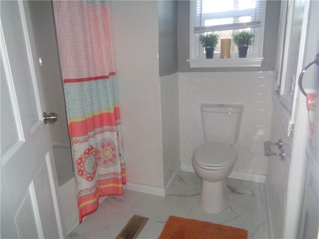full bathroom featuring marble finish floor, toilet, and visible vents