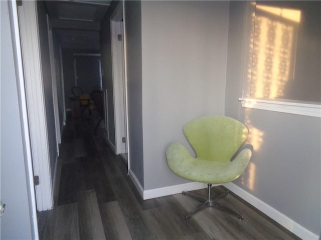 hallway featuring baseboards and wood finished floors