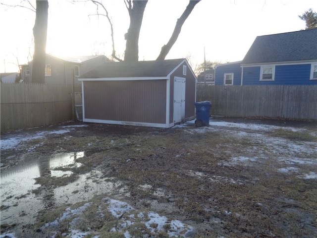 garage featuring fence and a storage shed