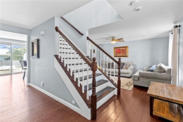 staircase featuring baseboards, ceiling fan, and hardwood / wood-style flooring