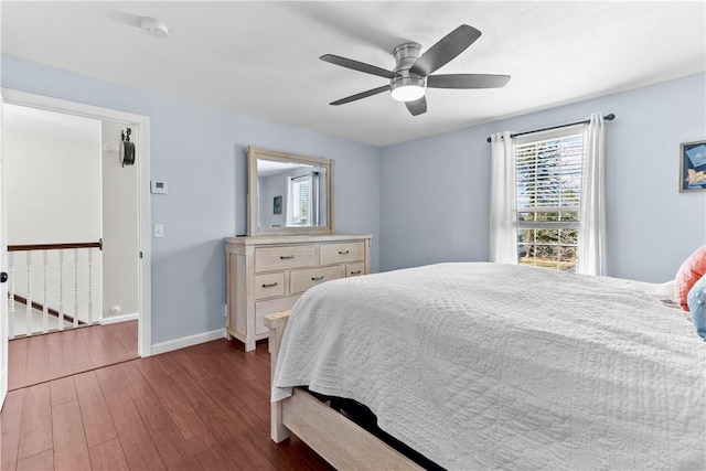 bedroom featuring baseboards, wood finished floors, and a ceiling fan