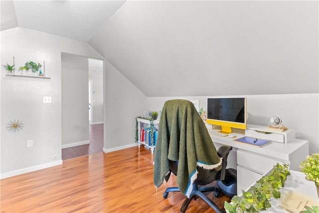 office area with baseboards, wood finished floors, and vaulted ceiling
