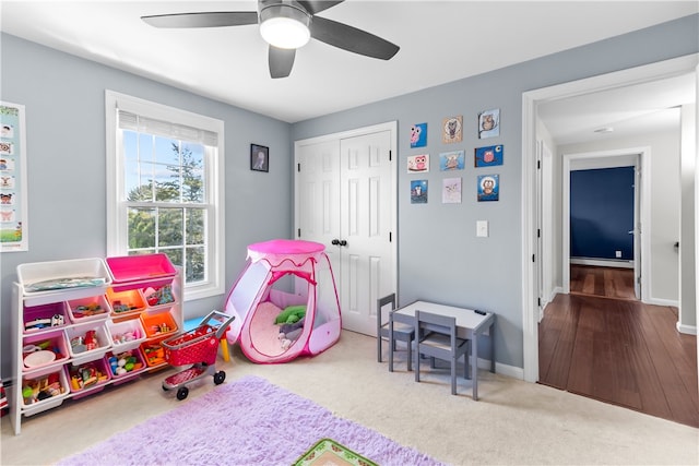 playroom with baseboard heating, carpet floors, baseboards, and a ceiling fan