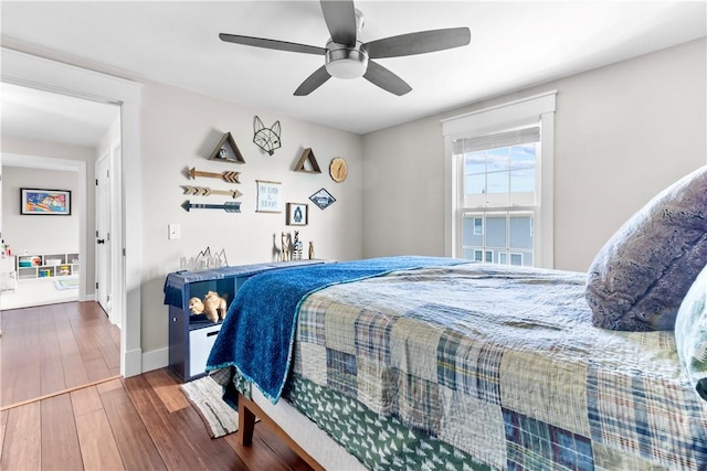 bedroom with baseboards, ceiling fan, and wood finished floors