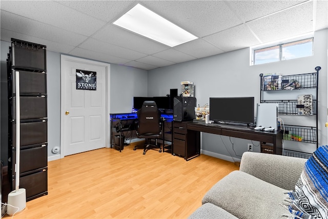 office featuring baseboards, wood finished floors, and a paneled ceiling