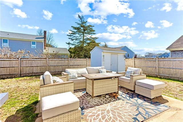 view of patio / terrace featuring an outdoor living space, an outbuilding, a fenced backyard, and a shed