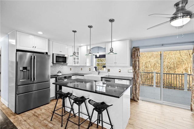 5 Nottingham Way, Freetown, MA 02702 - kitchen with appliances with stainless steel finishes, a sink, a kitchen bar, backsplash, and a ceiling fan