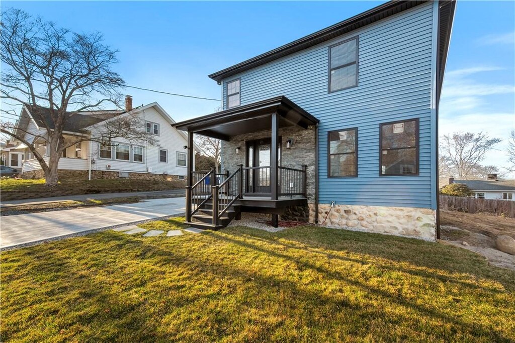 traditional-style house featuring covered porch and a front lawn