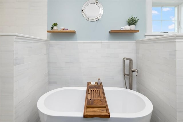 full bath featuring tile walls, wainscoting, and a freestanding bath