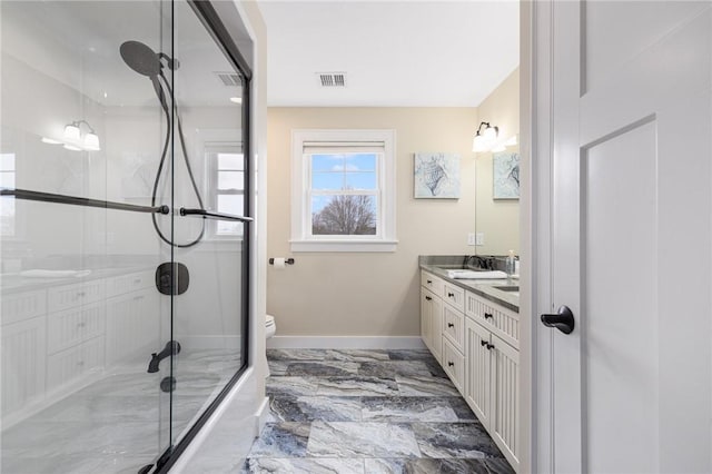 bathroom featuring visible vents, baseboards, marble finish floor, a shower with shower door, and vanity