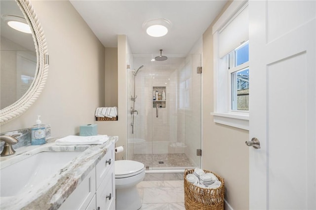 full bathroom featuring marble finish floor, toilet, a stall shower, and vanity