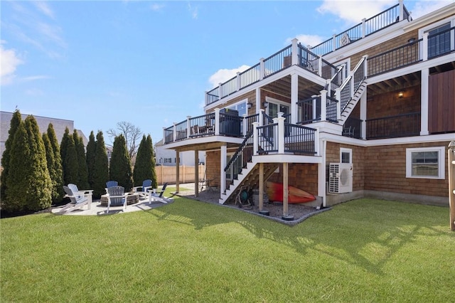 rear view of property featuring stairway, ac unit, an outdoor fire pit, a yard, and a patio area