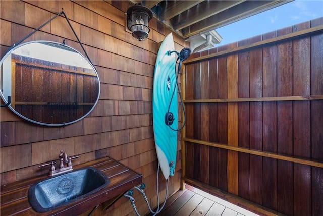 bathroom with wooden walls and a sink