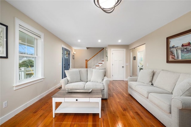 living area featuring hardwood / wood-style floors, baseboards, stairs, and recessed lighting