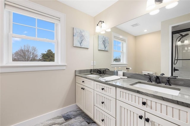bathroom with marble finish floor, baseboards, toilet, and a sink