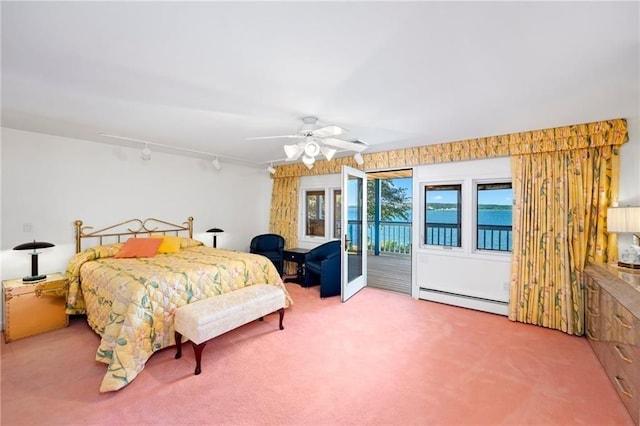bedroom with access to outside, a baseboard heating unit, track lighting, ceiling fan, and carpet