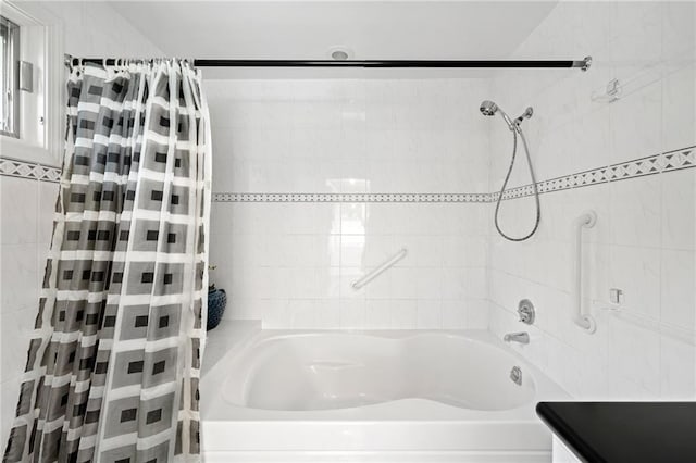 bathroom with tile walls and shower / tub combo with curtain