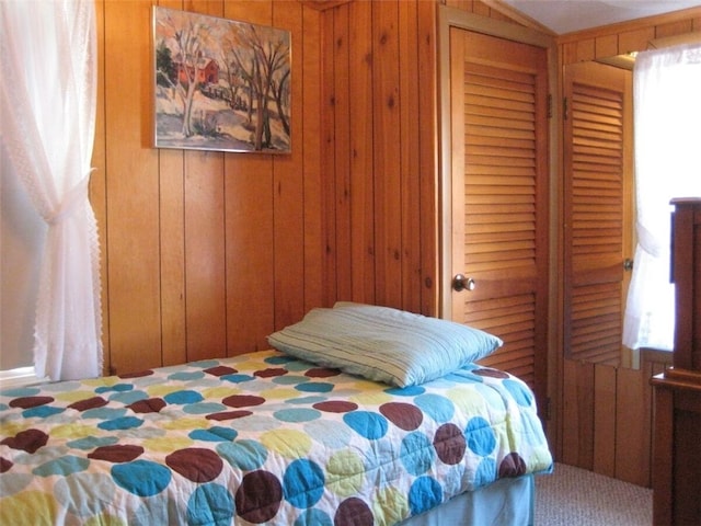 bedroom with a closet and wooden walls