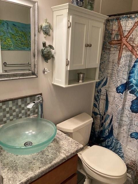 bathroom featuring vanity, tasteful backsplash, a shower with curtain, and toilet