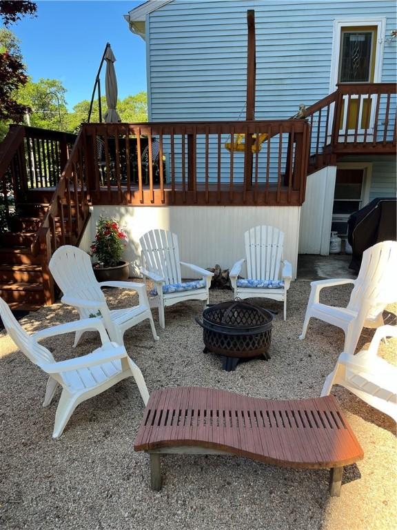 view of patio / terrace featuring stairs, a fire pit, and a wooden deck
